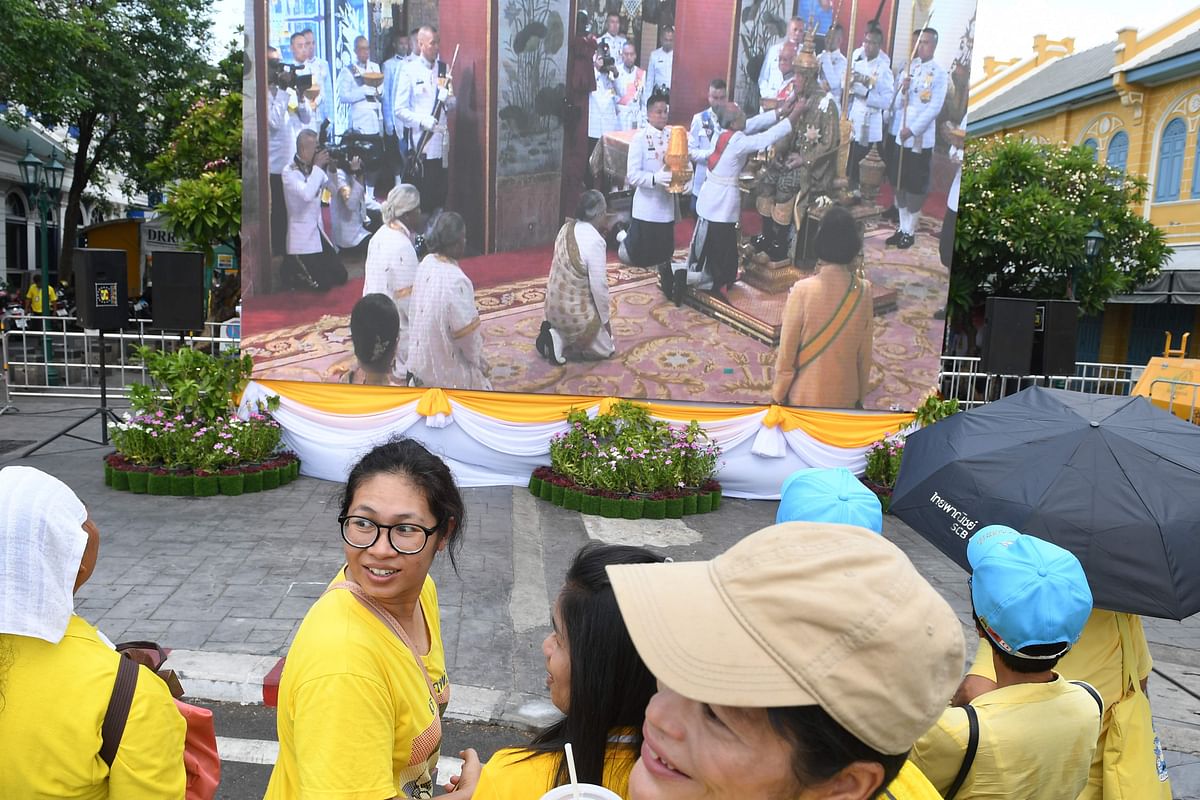 People watch a live broacast as Thailand`s King Maha Vajiralongkorn is crowned during his coronation in Bangkok on 4 May 2019. AFP