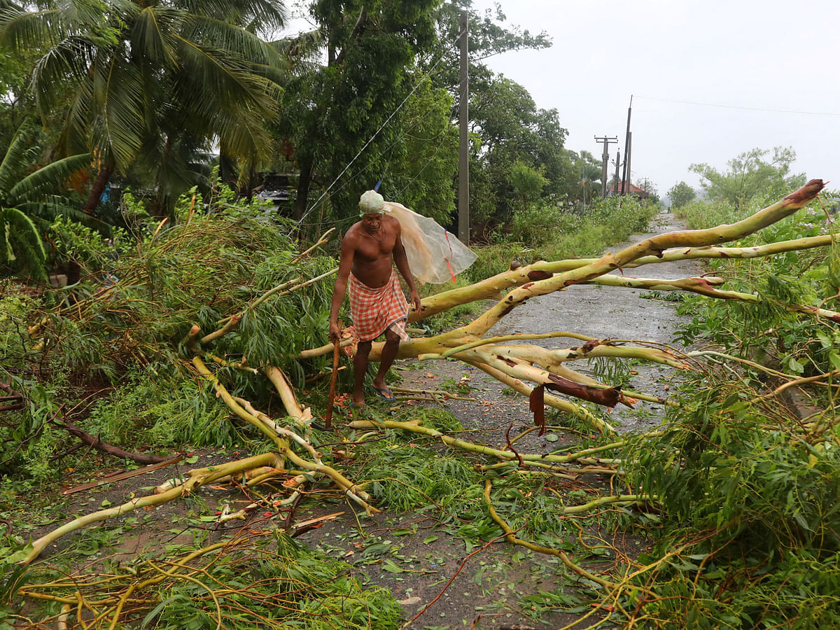A man cuts branches of an uprooted tree following Cyclone Fani in Khordha district in the eastern state of Odisha, India, on 3 May 2019. Reuters