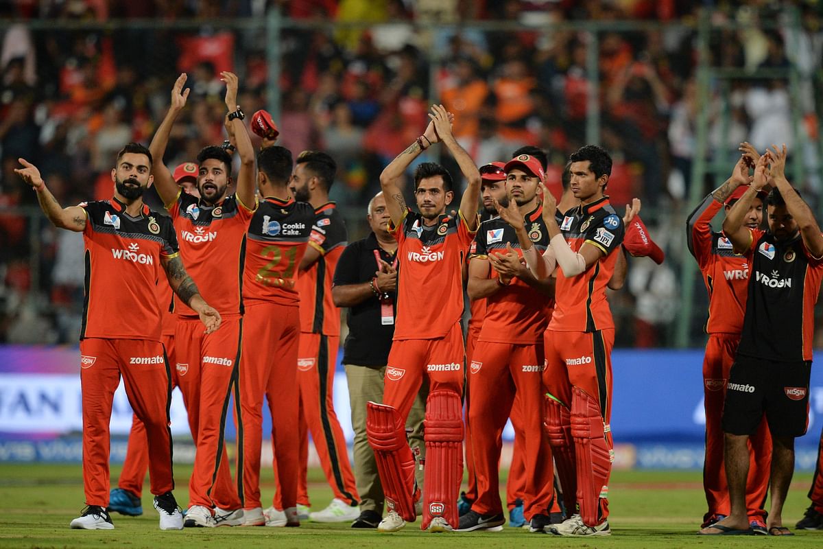 Royal Challengers Bangalore` team, along with their captain Virat Kohli (L), applaud to thank the support of the home crowd as they celebrate their team`s victory during the 2019 Indian Premier League Twenty20 cricket match against Sunrisers Hyderabad at The M Chinnaswamy stadium in Bangalore, on 4 May 2019. AFP