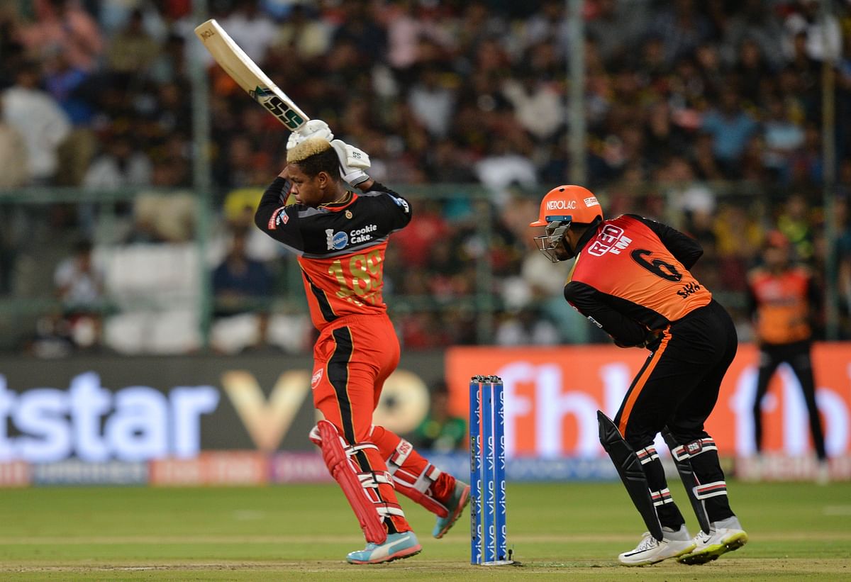 Royal Challengers Bangalore batsman Shimron Hetmyer (L) plays a shot while Sunrisers Hyderabad wicket keeper Wriddhiman Saha (R) looks on during the 2019 Indian Premier League (IPL) Twenty20 cricket match at The M Chinnaswamy stadium in Bangalore, on 4 May 2019. AFP