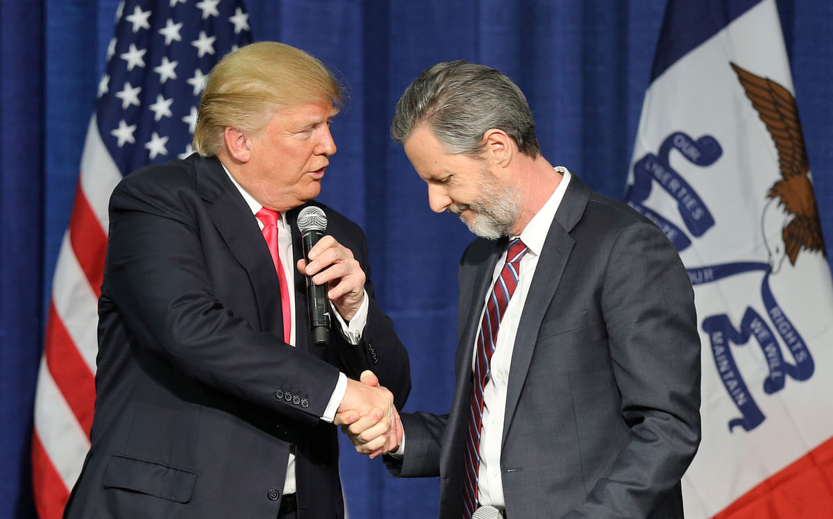US Republican presidential candidate Donald Trump (L) shakes hands with Jerry Falwell Jr. at a campaign rally in Council Bluffs, Iowa, January 31, 2016.