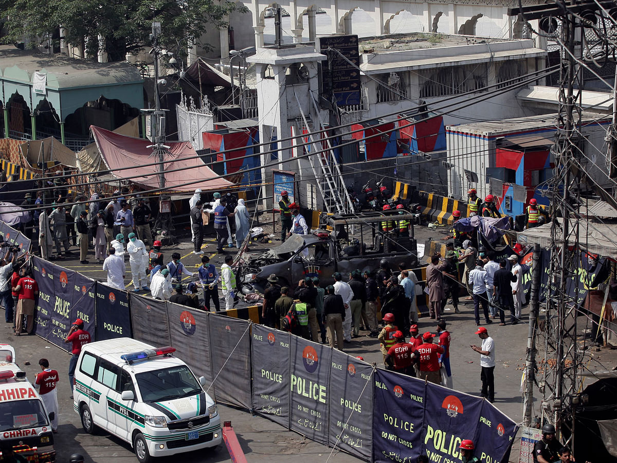 Ambulances are parked outside a cordoned off area as rescue workers and a bomb disposal team survey the site after a blast in Lahore, Pakistan on 8 May 2019. Photo: Reuters
