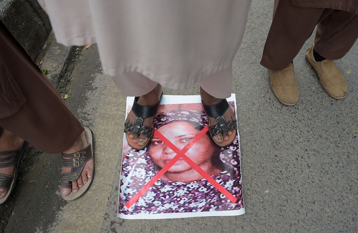 In this file photo taken on 2 November 2018 a Pakistani supporter of the Ahle Sunnat Wal Jamaat (ASWJ), a hard line religious party, stands on an image of Christian woman Asia Bibi as they march during a protest rally following the Supreme Court`s decision to acquit Bibi of blasphemy, in Islamabad. Photo: AFP