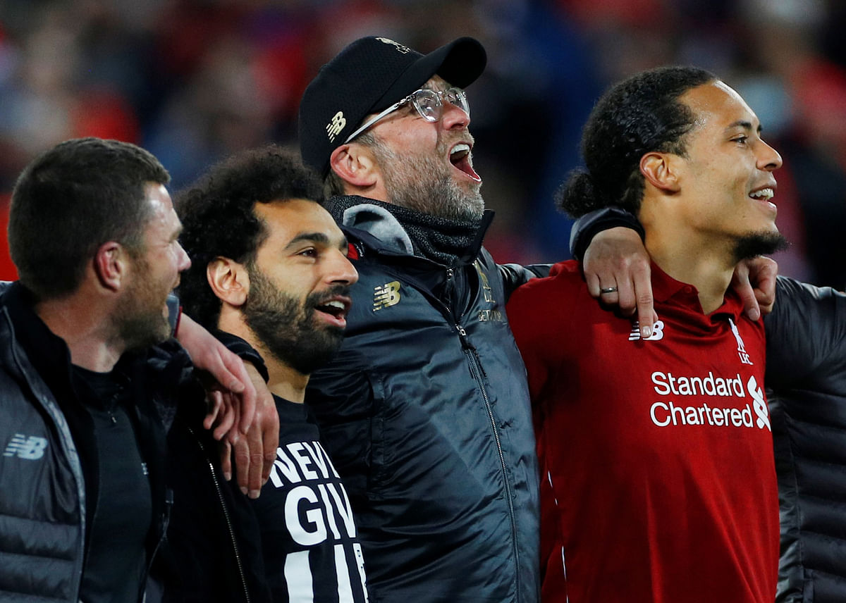 Liverpool`s Mohamed Salah, manager Juergen Klopp and Virgil van Dijk celebrate in front of their fans after the match. Photo: Reuters