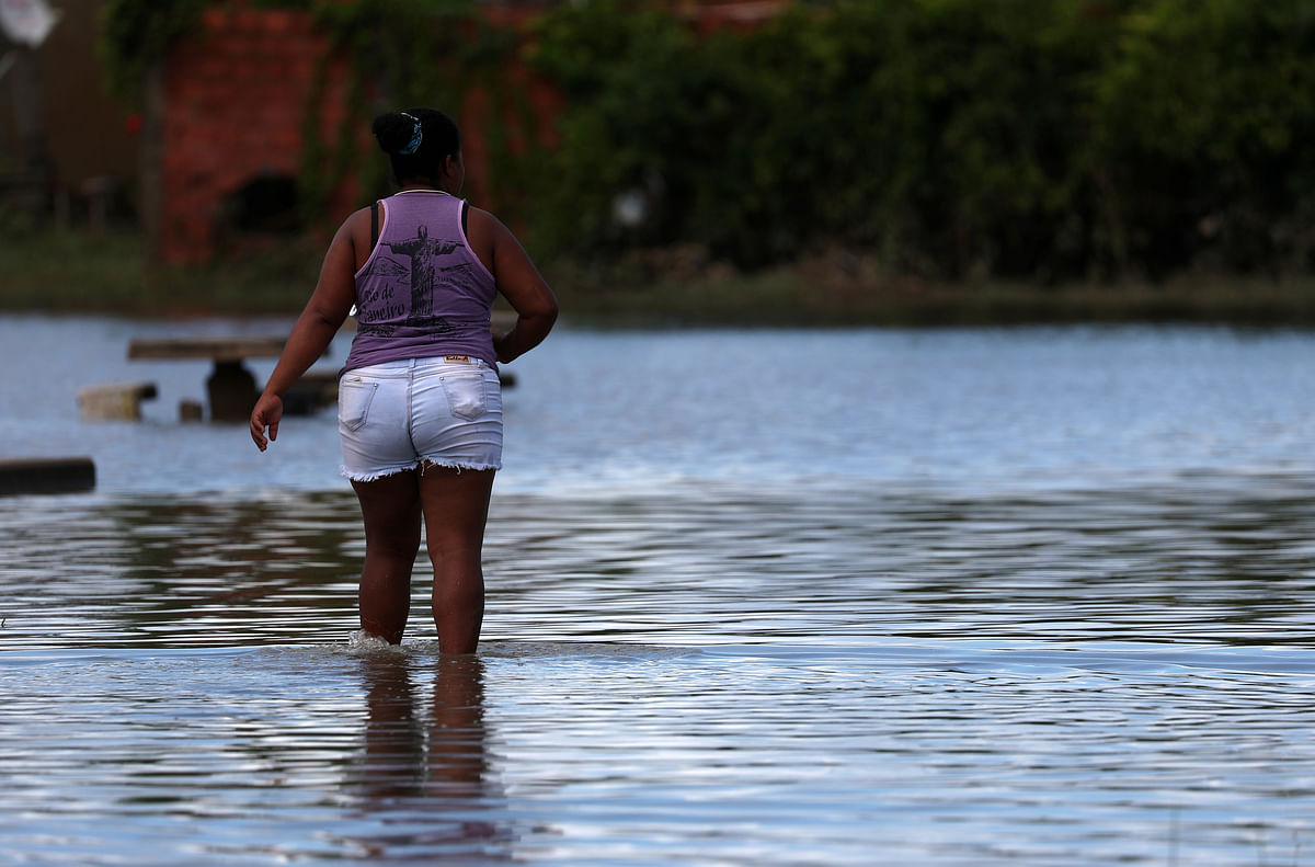 A resident is pictured at a flooded street during heavy rains in the Guaratiba neighborhood in Rio de Janeiro. Photo: Reuters