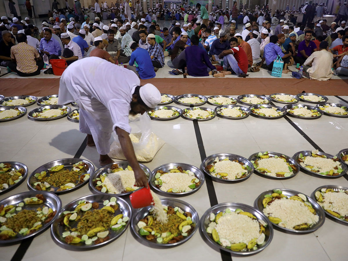 A volunteer arranges food plates at the Baitul Mokarram national mosque for the muslims to break fast during the fasting month of Ramadan in Dhaka, Bangladesh, on 8 May 2019. Photo: Reuters
