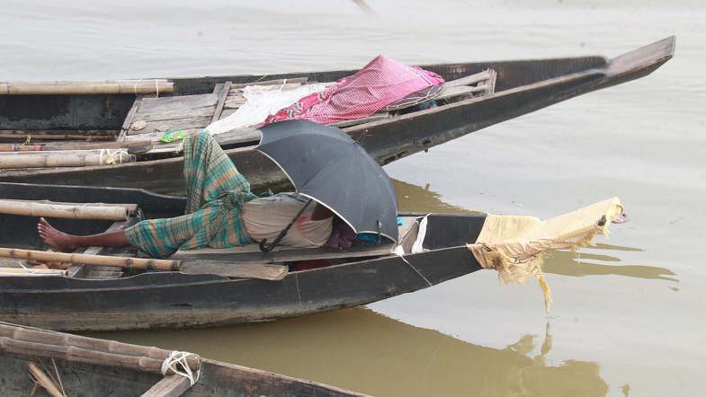 A boatman takes rest during scorching summer noon in Chandighat, Sylhet on 10 May. Photo: Anis Mahmud