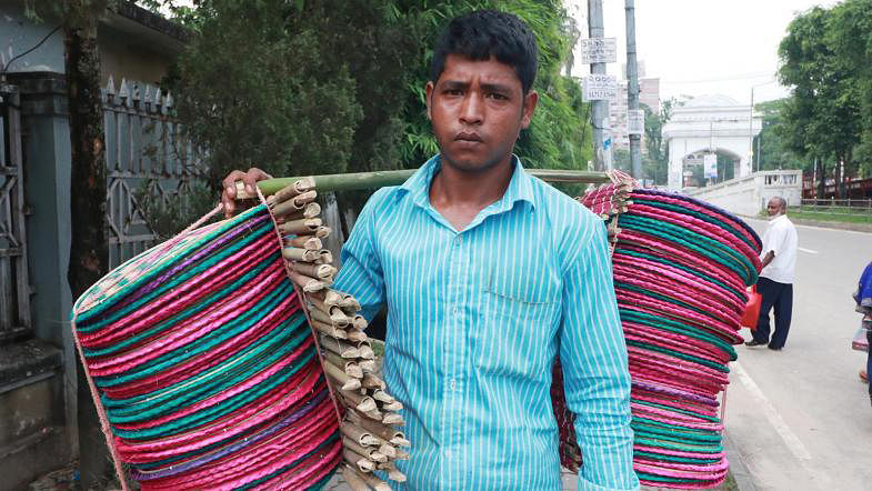 A man sells fans made of bamboo and palm leaf in Sylhet on 10 May. Photo: Anis Mahmud