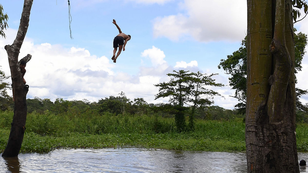 A boy dives into the river Mamiraua near the Vila Alencar community at the Mamiraua Reserve, Brazil`s largest protected area, in Amazonas State, on 24 April 2019. Photo: AFP
