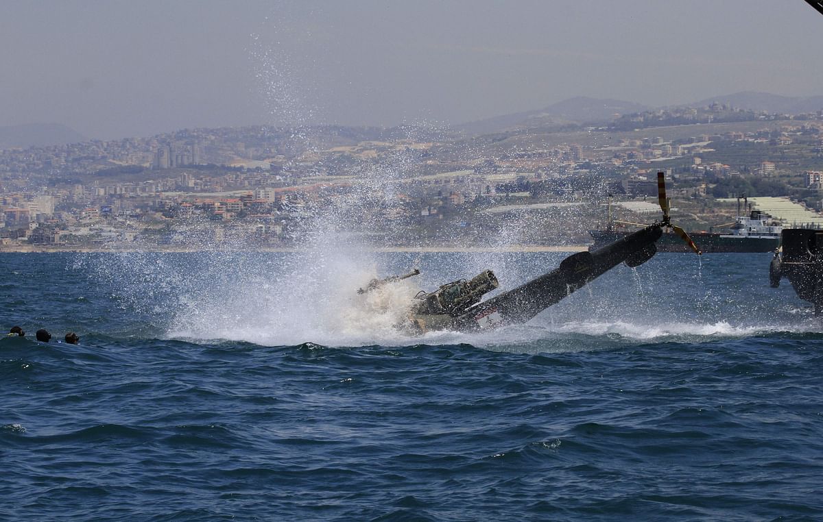 Members of the Lebanese ` Friends of Zira Island and Sidon`s Beach` association, submerge an old army helicopter in the Mediterranean, near the island of Zira,around 600 metres off the shore of the southern Lebanese coastal city of Sidon, on 11 May, 2019. Photo: AFP