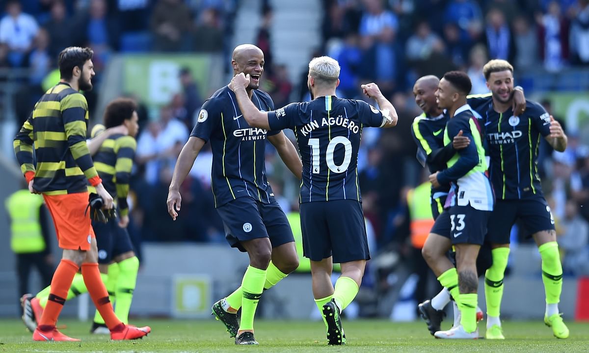 Manchester City`s Argentinian striker Sergio Aguero (CR) and Manchester City`s Belgian defender Vincent Kompany (L) celebrate at the final whistle of the English Premier League football match between Brighton and Hove Albion and Manchester City at the American Express Community Stadium in Brighton, southern England on 12 May 2019. Photo: AFP