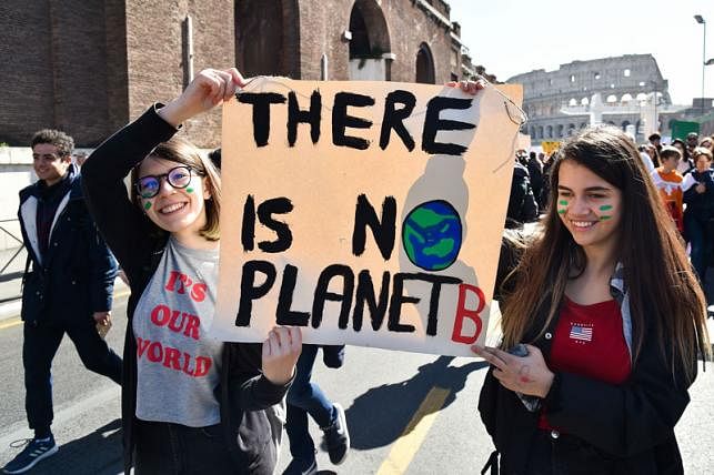 Students hold a placard during a protest against global warming in central Rome on 15 March 2019. Photo: AFP