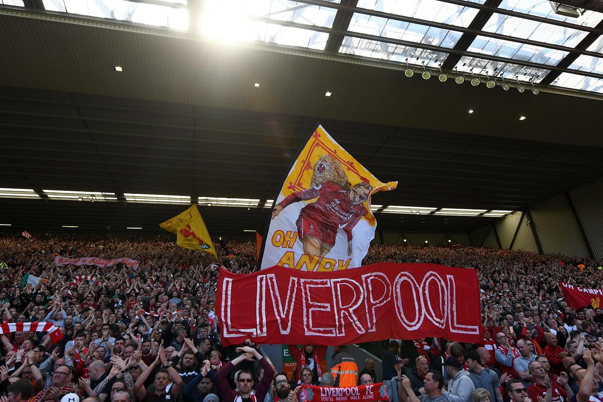 Liverpool fans wave flags in the crowd during the English Premier League football match between Liverpool and Wolverhampton Wanderers at Anfield in Liverpool, north west England on 12 May 2019. Photo: AFP