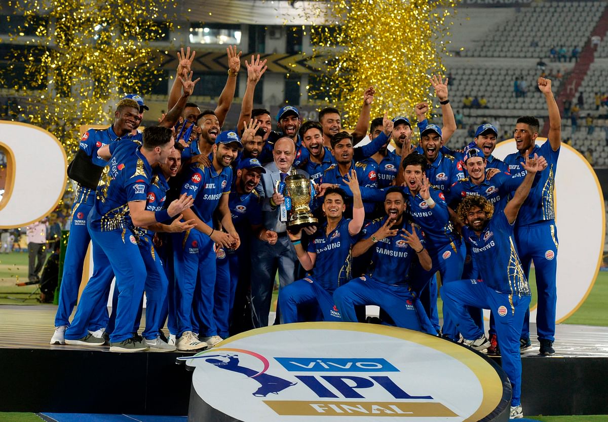 Mumbai Indians team players hold the trophy as they celebrate their victory against Chennai Super Kings after the 2019 Indian Premier League (IPL) Twenty20 final cricket match at the Rajiv Gandhi International Cricket Stadium in Hyderabad on 12 May, 2019. Photo: AFP