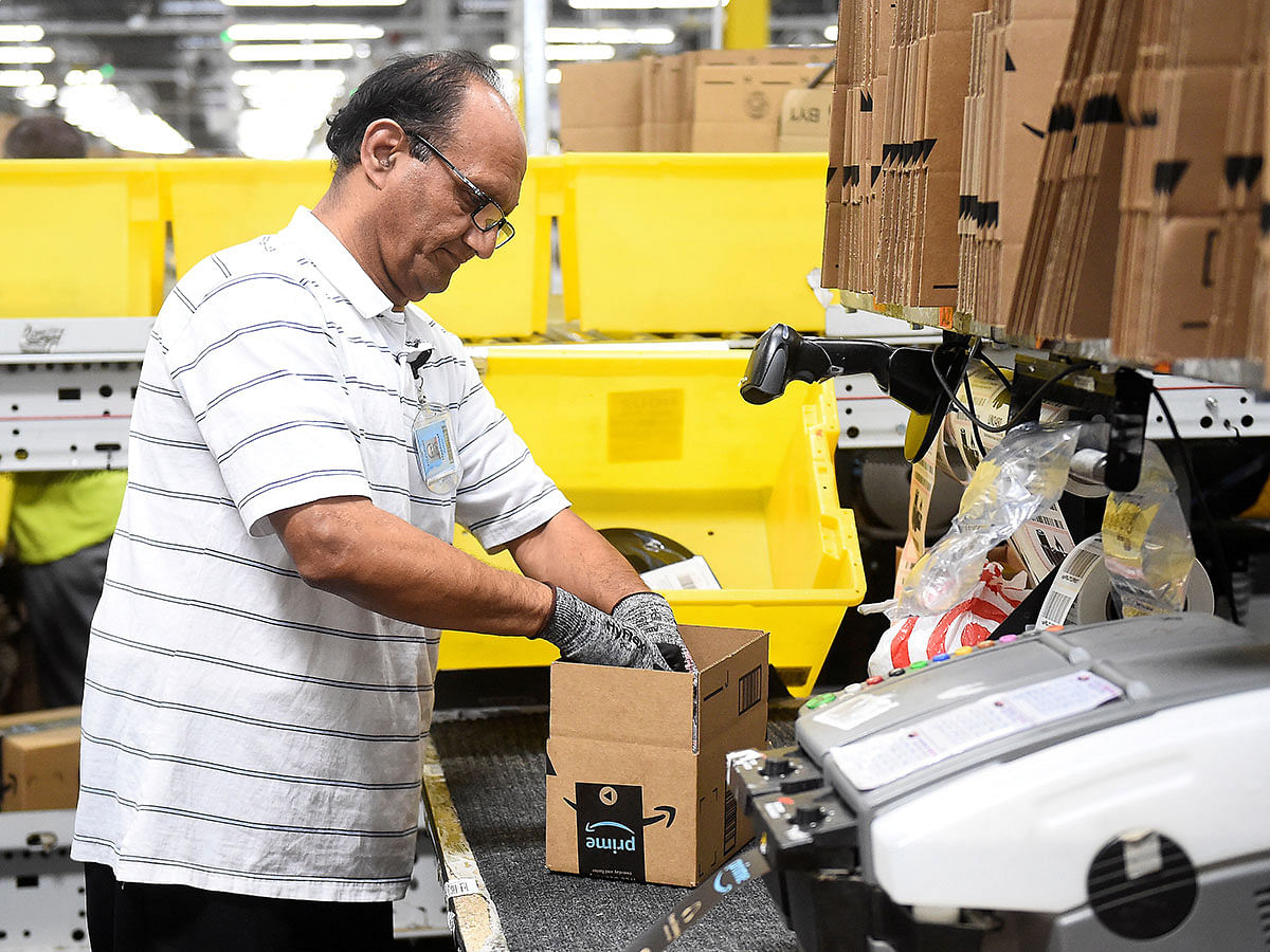 Packing worker Zubair fills a delivery box with products at the Amazon fulfillment center in Baltimore. Photo: Reuters