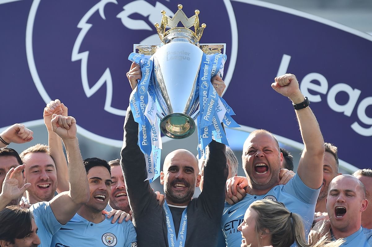 Manchester City's Spanish manager Pep Guardiola holds up the Premier League at the American Express Community Stadium in Brighton, southern England on 12 May, 2019. Photo: AFP