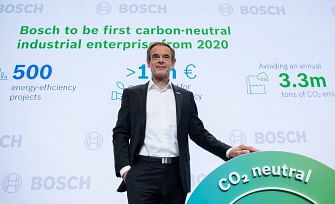 Volkmar Denner, CEO of Robert Bosch GmbH, poses next to a sign indicating the company`s aim to produce CO2-neutral during Bosch`s annual press conference on 9 May 2019 in Renningen, southern Germany. Photo: AFP