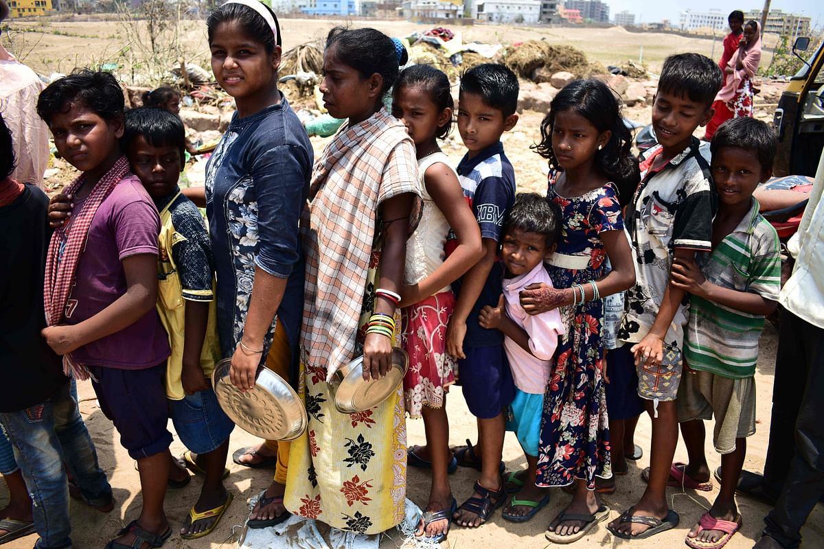In this photo taken on 12 May 2019, Indian children queue to collect food handouts in Puri in the eastern Indian state of Odisha, following Cyclone Fani. The death toll from a major cyclone that hit eastern India and Bangladesh in early May rose to 77 on 13 May as anger grew over millions of people still without power and water. Photo: AFP
