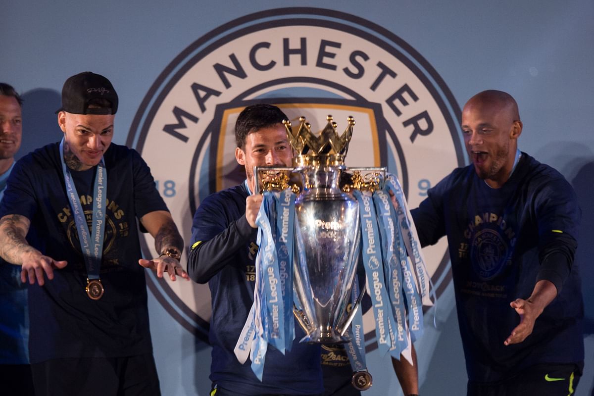 Manchester City`s Brazilian goalkeeper Ederson (L), Manchester City`s Spanish midfielder David Silva (C) and Manchester City`s Belgian defender Vincent Kompany show the Premier League trophy to supporters outside the Etihad Stadium in Manchester, northern England on 12 May 2019. Photo: AFP