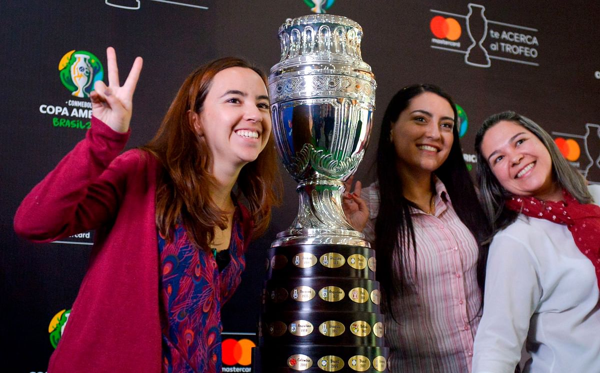 Women pose with the 2019 Copa America football tournament trophy in Bogota, on 7 May 2019. The Copa America 2019 will be held in Brazil next 14 June to 7 July. Photo: AFP