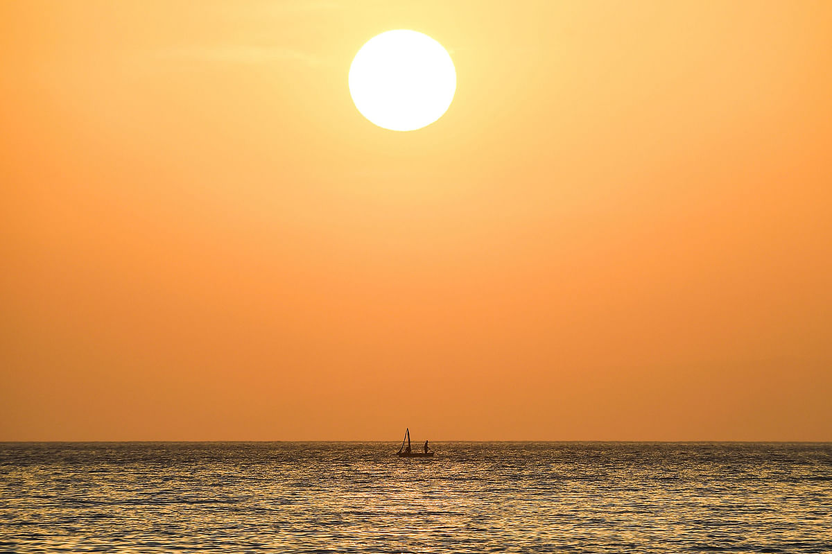 A fishermen stands on his boat under the setting sun on the Caribbean sea off the coast of Port-au-Prince, on 14 May 2019. Photo: AFP