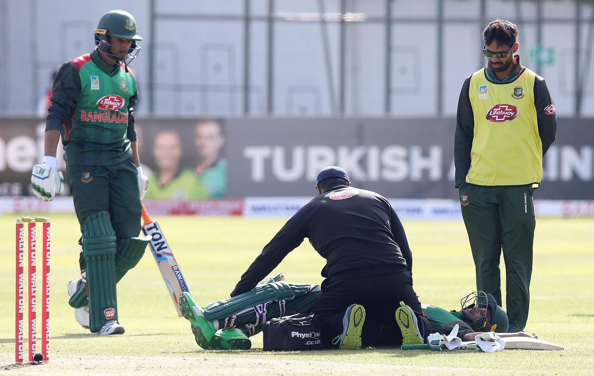 Bangladesh's Shakib Al Hasan (C) lays on the pitch injured before retiring during the Tri-Nation Series, one-day international between Ireland and Bangladesh at the Malahide cricket club, in Dublin on 15 May, 2019. Photo: AFP