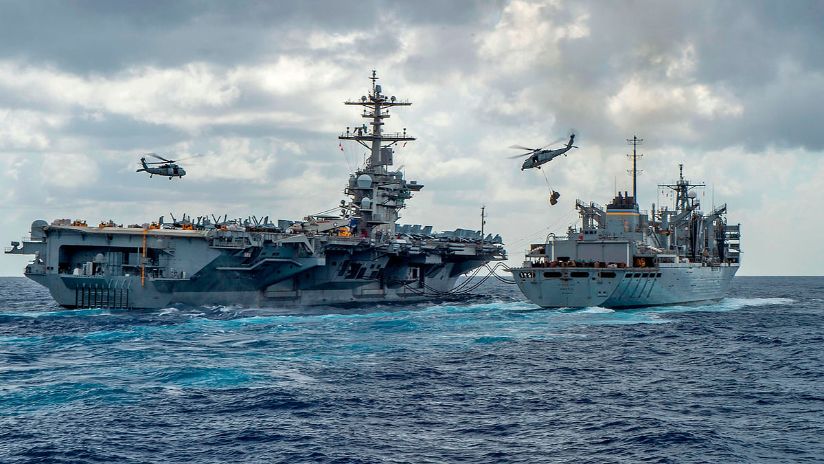 This handout picture released by the US Navy on 8 May shows the Nimitz-class aircraft carrier USS Abraham Lincoln (CVN 72) while conducting a replenishment-at-sea with the fast combat support ship USNS Arctic (T-AOE 9), while MH-60S Sea Hawk helicopters assigned to the `Nightdippers` of Helicopter Maritime Strike Squadron (HSM) 5, transfer stores between the ships. Photo: AFP