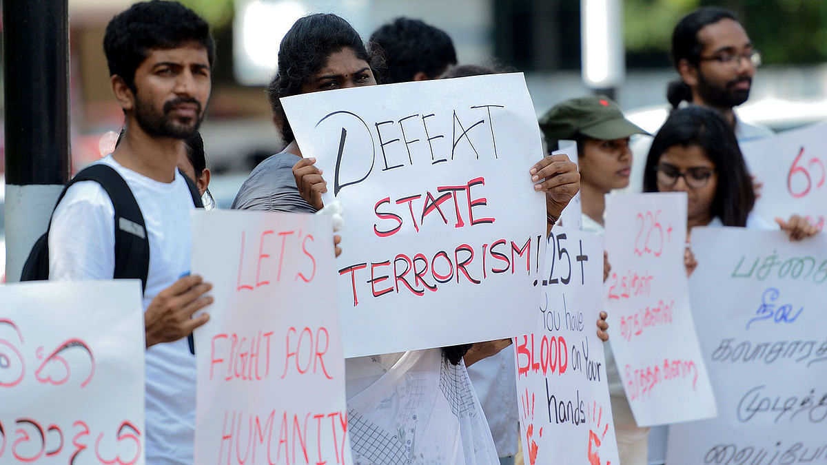 Sri Lankan people hold placards as they demonstrate against the anti-Muslim mob attacks in Colombo on 16 May 2019. Photo: AFP