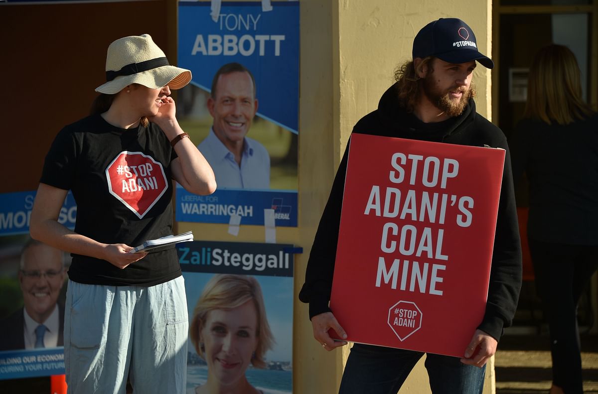 Climate change activists hold placards outside a polling station in the Liberal-held Sydney seat of Warringah during Australia`s general election in Sydney on 18 May. Photo: AFP