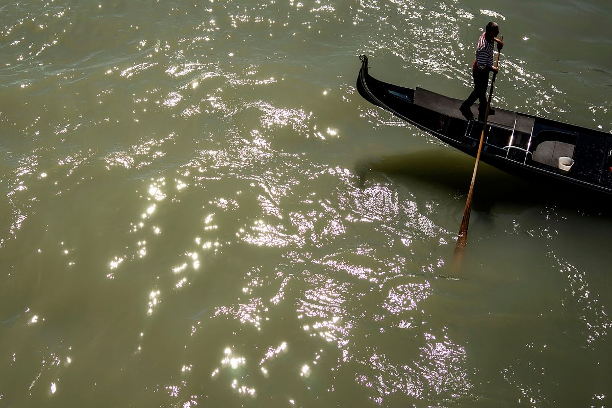 A punter propels a Gondola along on the Grand Canal in Venice, on 16 May 2019. Photo: AFP
