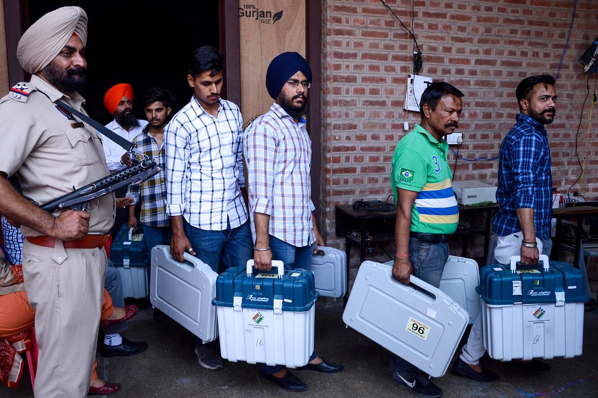 4An Indian Punjab Police personnel stands guard as election officials carry Electronic Voting Machines (EVM) and Voter-Verified Paper Audit Trail (VVPAT) leaving a distribution centre in Amritsar on 18 May 2019, on the eve of the 7th and final phase of India`s general election. Photo: AFP