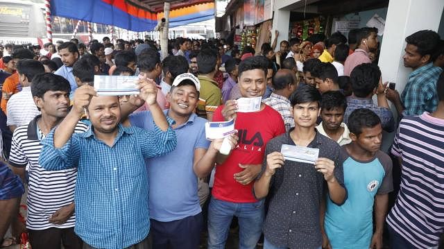 People happy after they collect tickets for bus before Eid. File photo