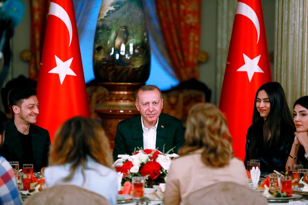 A handout photo released on 18 May, 2019 by the Turkish President`s press office shows Turkish president Recep Tayyip Erdogan (C) next to Arsenal`s German soccer player Mesut Ozil (L), who is of Turkish descent, and his fiancee Amine Gulse (R) during an iftar dinner in Istanbul. Photo: AFP