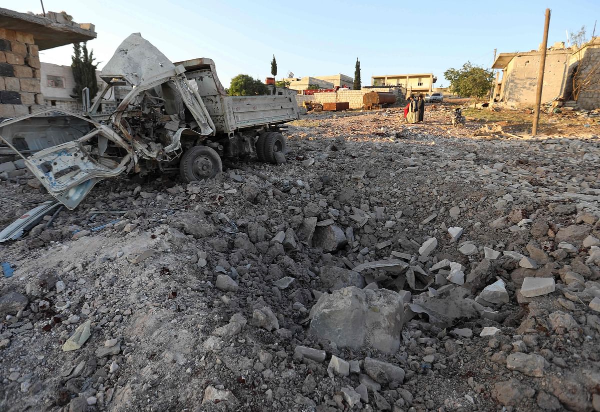 A damaged vehicle lies next to a crater cased by reported airstrikes by the Syrian regime ally Russia, in the town of Kafranbel in the rebel-held part of the Syrian Idlib province on 20 May. Photo: AFP