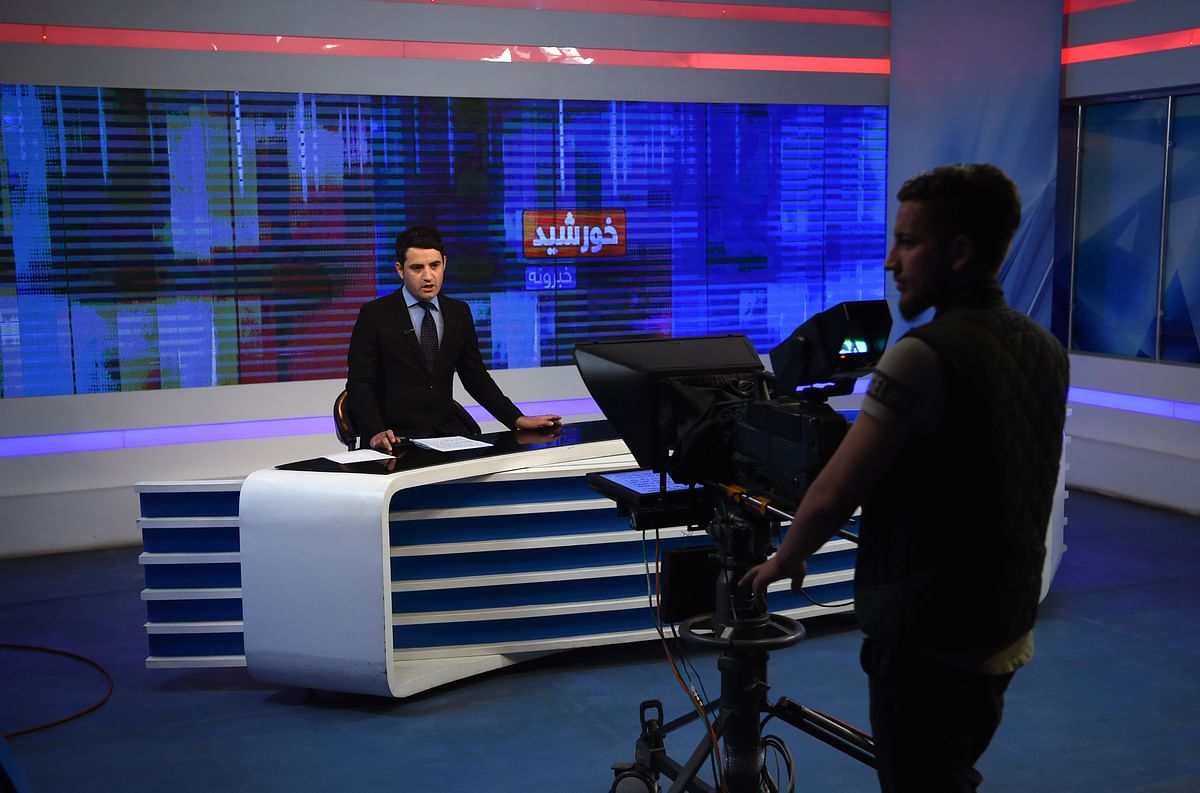 In this photo taken on 4 April 2019 an Afghan presenter takes part in a live broadcast at the Khurshid TV station in Kabul. Photo: AFP
