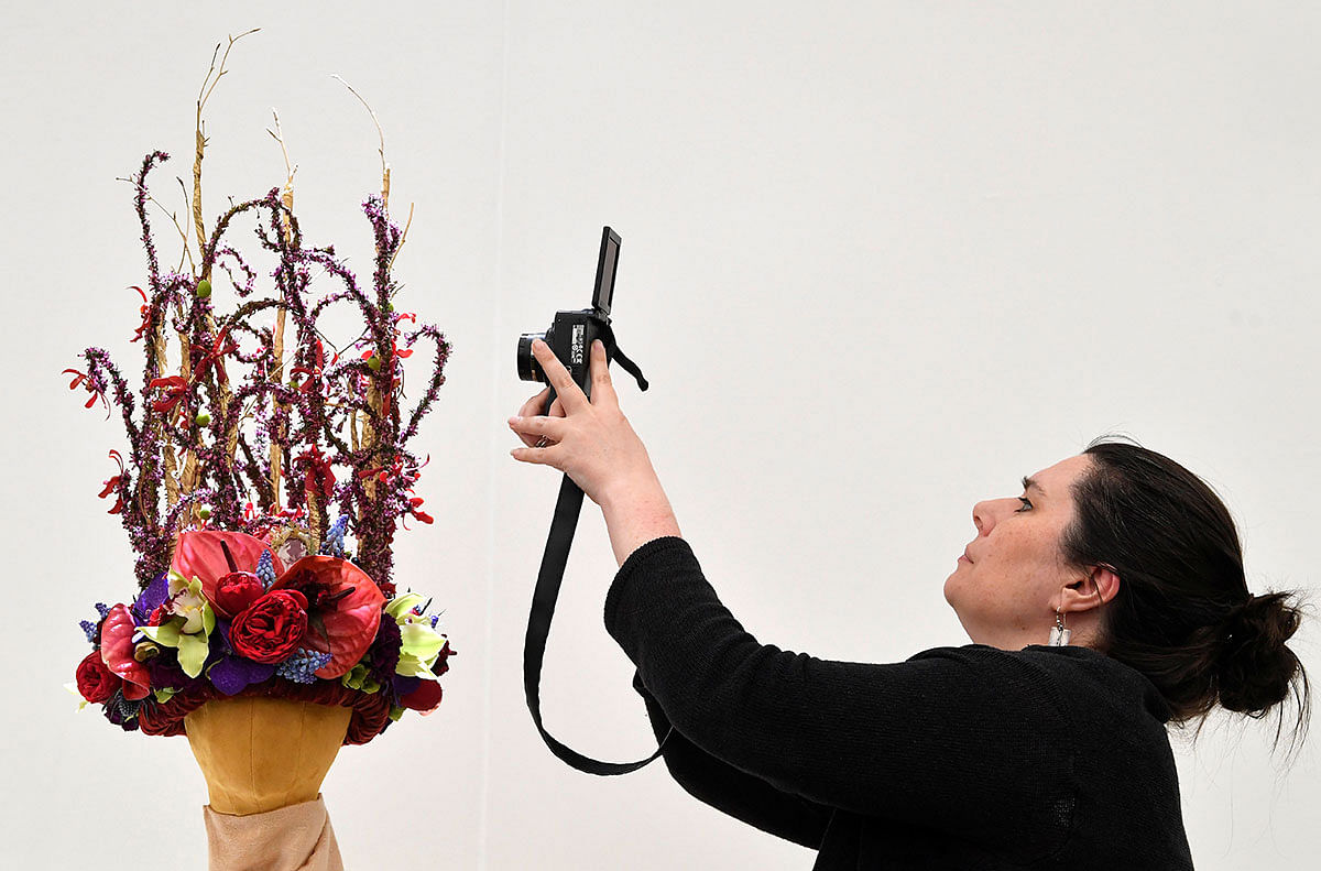 A woman photographs a floral headdress design at the RHS Chelsea Flower Show at the Royal Hospital Chelsea, London, Britain, 20 May, 2019. Photo: Reuters