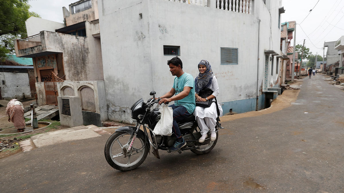 Sharfuddin, a cloth shop owner and his niece Aisha, a law student, ride a motorbike in village Nayabans in the northern state of Uttar Pradesh, India on 15 May 2019. Reuters