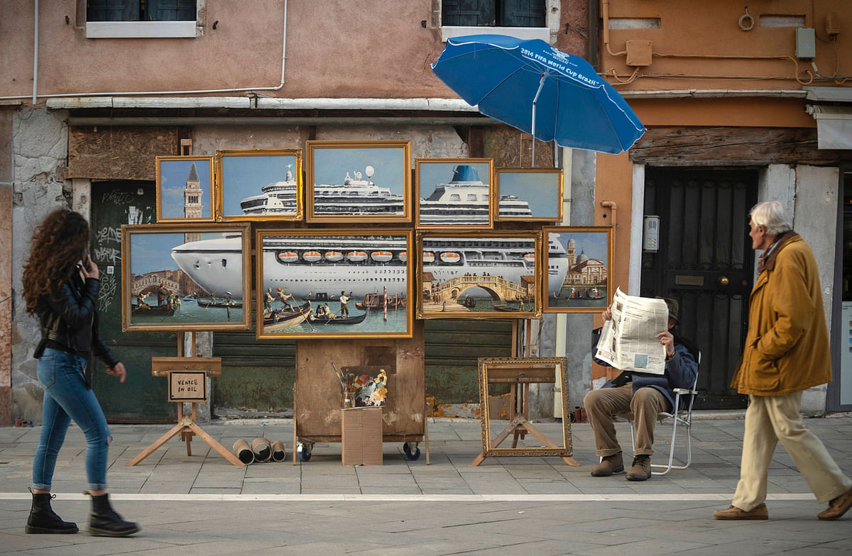 A street stall with oil paintings creating an image of a yacht in the Venice canal with a sign reading `Venice in oil`, set up by a person purporting to be British artist Banksy, in Venice, Italy, 22 May 2019, in this image obtained from Banksy`s social media. Photo: Reuters