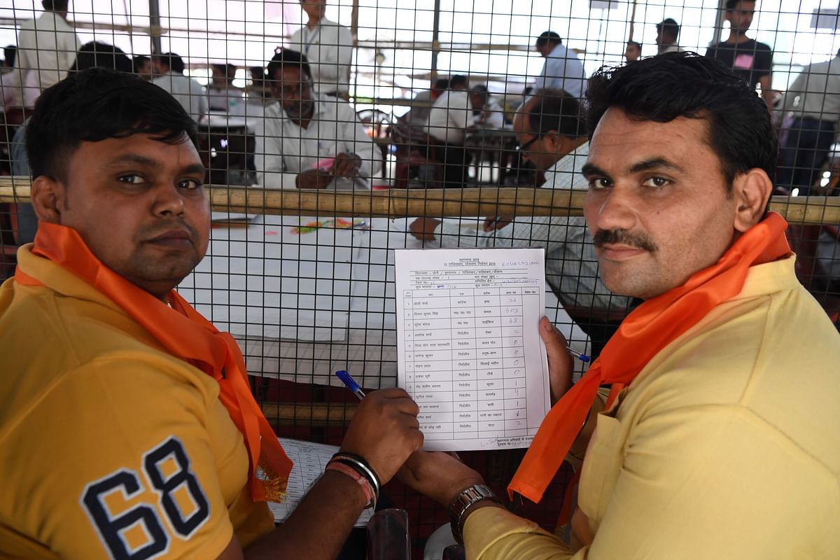 Indian poll agent shows details of votes that candidates got after the first round of counting at a counting centre in Ghaziabad on 23 May 2019. AFP