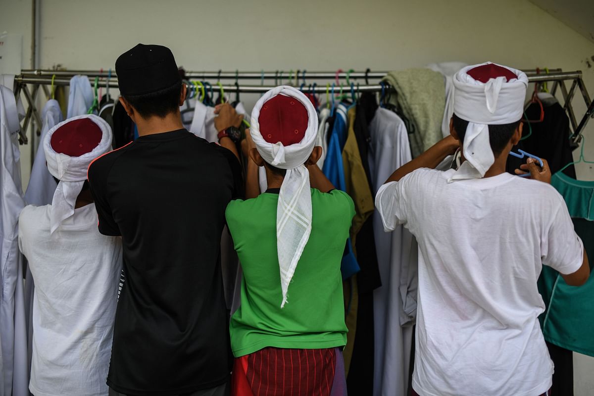 Religious Muslim students prepare their outfits before reading and memorising the Koran at a seminary during the Islamic holy fasting month of Ramadan in Bentong, outside Kuala Lumpur in the nearby Pahang state on 16 May 2019. Photo: AFP