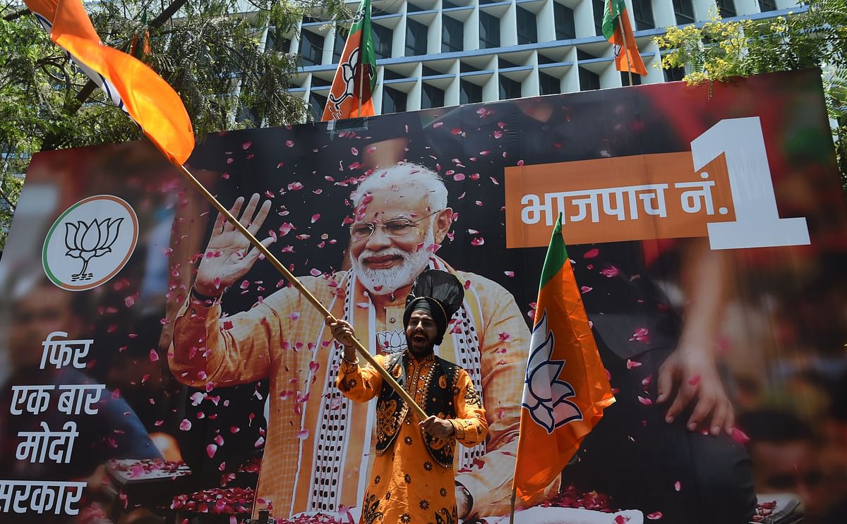 An Indian supporter of Indian Prime Minister Narendra Modi`s Bharatiya Janata Party (BJP) celebrates the election results outside the BJP headquarters in Mumbai on 23 May 2019. Photo: AFP