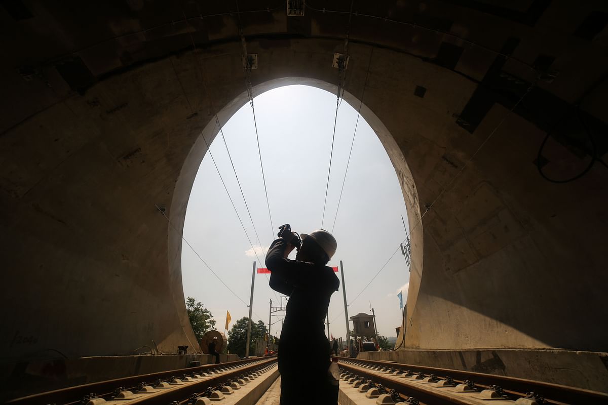 This photo taken on 22 May 2019 shows a worker inspecting overhead lines at a tunnel entrance on a new section of China`s high-speed rail network at Bijie, in China`s southwest Guizhou province. The new section, between Chengdu and Guiyang, is expected to go into service in December 2019. Photo: AFP
