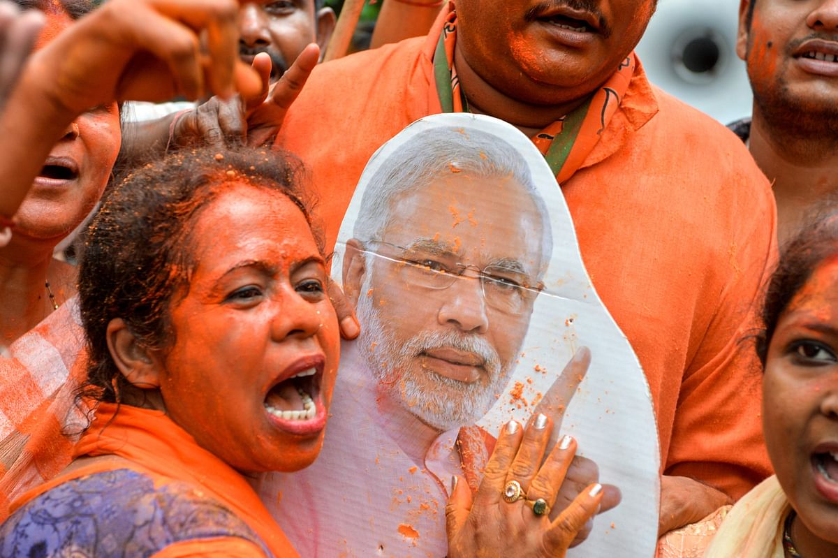 An Indian supporter of Bharatiya Janata Party (BJP) shouts slogans and a cut-out of Indian Prime Minister Narendra Modi as she celebrates on the vote results day for India`s general election in Siliguri on 23 May 2019. Photo: AFP