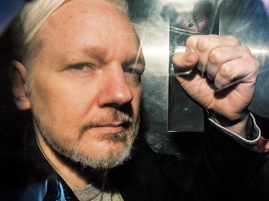 In this file photo taken on 1 May 2019 WikiLeaks founder Julian Assange gestures from the window of a prison van as he is driven into Southwark Crown Court in London, before being sentenced to 50 weeks in prison for breaching his bail conditions in 2012. Photo: AFP