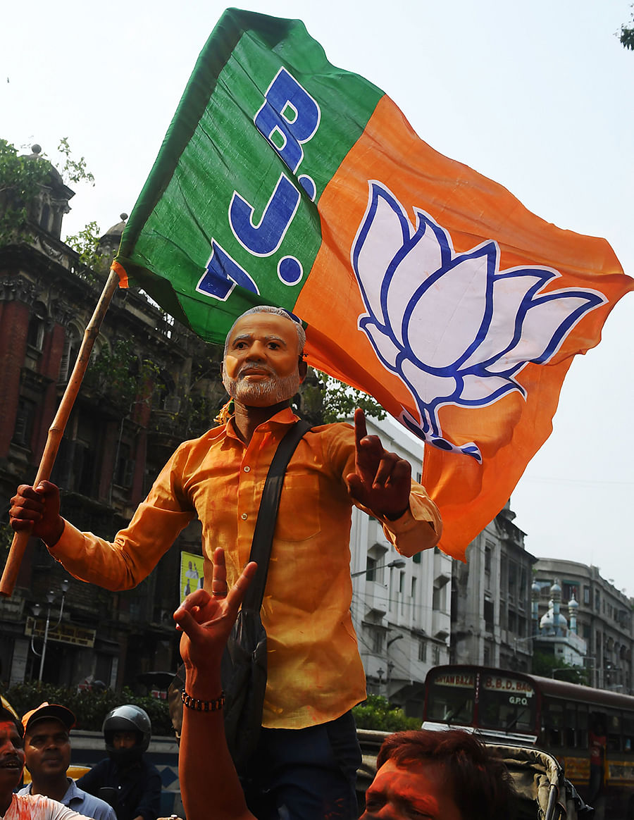An Indian supporter of the Bharatiya Janata Party (BJP) wearing a mask of Prime Minister Narendra Modi celebrates with others during the vote results day of India`s general election, in Kolkata on 23 May 2019. Photo: AFP
