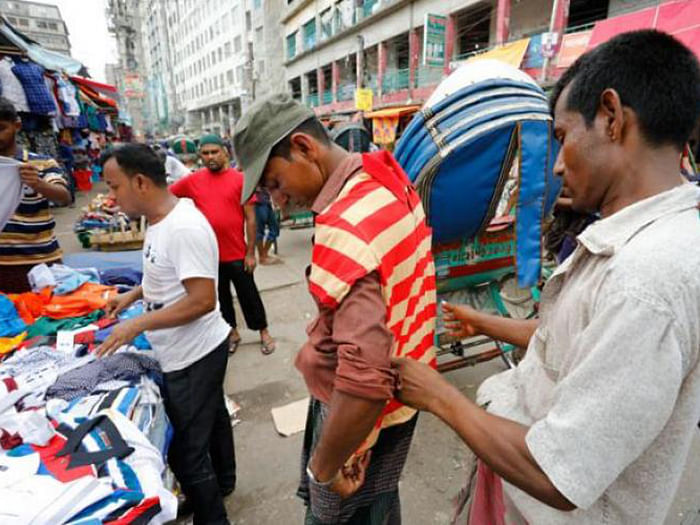 A rickshaw puller buys a t-shirt before Eid in Dhaka. Prothom Alo File Photo
