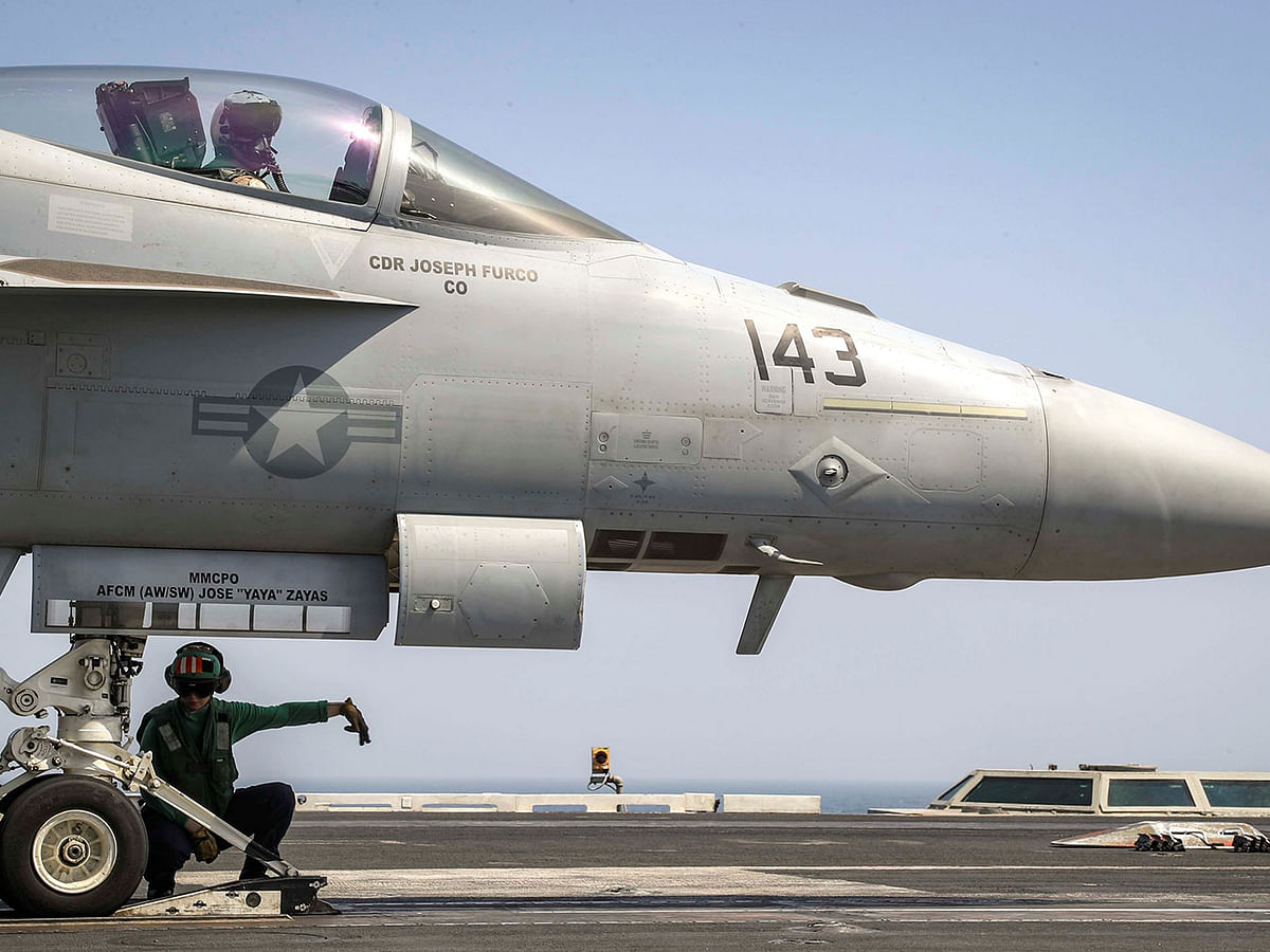 A flight deck crew ensures an F/A-18E Super Hornet is seated in the catapult shuttle on the flight deck of the aircraft carrier USS Abraham Lincoln (CVN 72), in Arabian Sea. Photo: Reuters