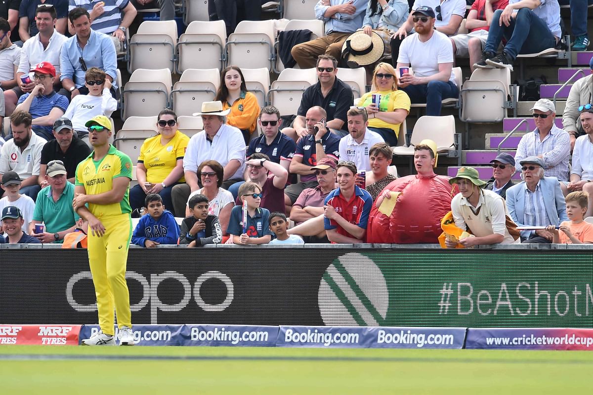 A fan dressed as a cricket ball holds a piece of sandpaper in the crowd and shouts to Australia`s Marcus Stoinis (L) as he fields during the 2019 Cricket World Cup warm up match between England and Australia at the Rose Bowl in Southampton, southern England, on 25 May 2019. Photo: AFP