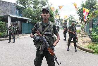 Sri Lankan army soldiers stand guard at a checkpoint on a roadside during special cordon-and-search operations in Colombo on 25 May 2019. Sri Lanka`s military launched a major hunt on 25 May for remnants of an Islamist group which carried out the Easter suicide bombings that killed 258 people, officials said. Photo: AFP