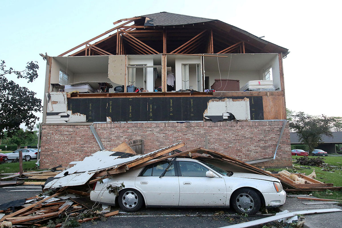A car is covered with debris that was ripped from an apartments building after a tornado touched down overnight in Trotwood, Ohio. Photo: Reuters
